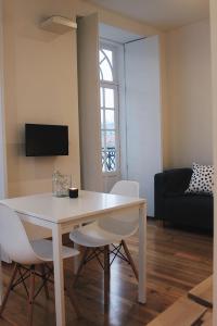 Una sala de estar con una mesa y sillas blancas. en Lost Apartments, en Oporto