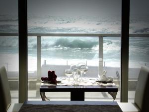 a table with wine glasses and a view of the ocean at Arribas Sintra Hotel in Sintra
