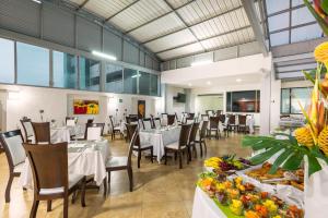 un comedor con mesas y sillas con comida. en Hotel Dann Combeima, en Ibagué