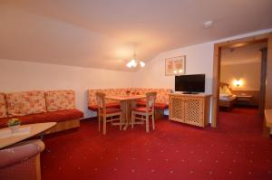 ein Wohnzimmer mit einem Tisch und einem Sofa in der Unterkunft Apartments & Zimmer Urschnerhof in Pertisau