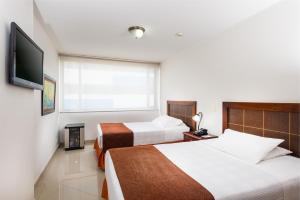 Ліжко або ліжка в номері Hotel Dann Combeima