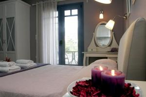 Cette chambre comprend un lit avec deux bougies et un miroir. dans l'établissement Boutique Hotel Iasmos, à Trizonía