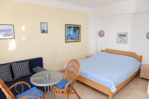 a bedroom with a bed and a table and a couch at Apartments Lončar in Gradac