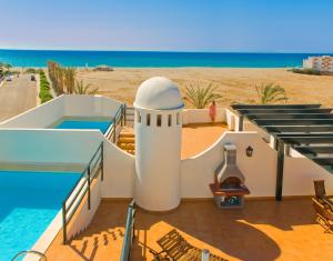 a house on the beach with a swimming pool at Apartamentos Paraiso Playa in Vera