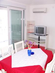 a dining room table with a red and white table cloth and a vase at Apartments Perdijic Nemira in Omiš