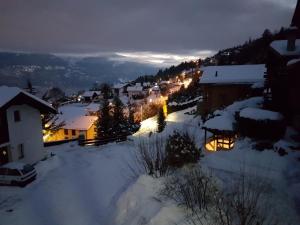 Une petite ville dans la neige la nuit dans l'établissement Mollens Chalet, à Mollens