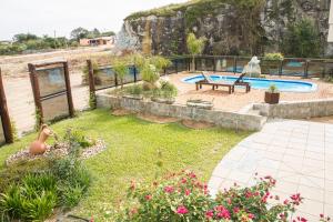 a garden with a pool and a bench and flowers at Pousada Pedra Bonita in Cristal
