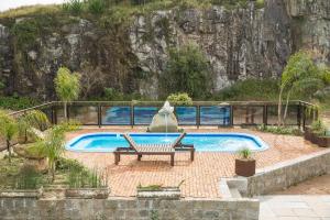 a swimming pool with a bench next to at Pousada Pedra Bonita in Cristal