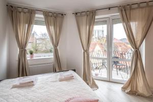 a bedroom with a bed and a large window at Bed4You in Zielona Góra