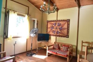 sala de estar con ventilador, silla y TV en Los Arrayanes en Tandil
