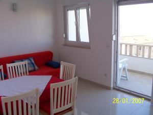 a living room with a red couch and a table and chairs at Apartments Perdijic Nemira in Omiš