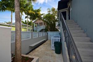 a staircase leading to a house with palm trees at Pescado Penthouse On Duval in Key West