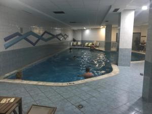 ein Pool in einem Hotel mit Menschen im Wasser in der Unterkunft Flora Apartment 619 in Borowez