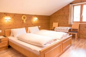 a bedroom with a large bed in a room with wooden walls at Landhaus Alpenrose in Mayrhofen