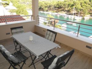 a table and chairs in a balcony with a view of the water at Apartment Aurea in Primošten