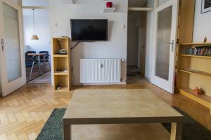uma sala de estar com uma mesa e uma televisão na parede em Photographer's Nest em Liubliana