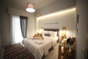 - une chambre avec un grand lit blanc et une fenêtre dans l'établissement Ports Crossroad B, au Pirée