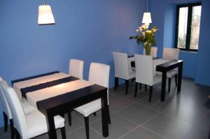 a dining room with white chairs and tables and a blue wall at B&B La Terrazza Sul Borgo - Ortona Rooms in Ortona