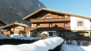 a building with snow in front of it at Landhaus Alpenrose in Mayrhofen