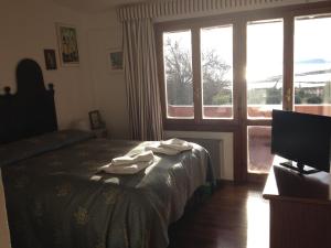 a bedroom with a bed and a window with a television at Al Sandalyon in Quartu SantʼElena