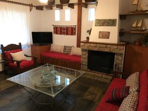 a living room with red furniture and a fireplace at Villa Kazantzakis in Archanes