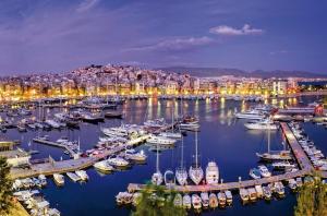 a harbor with boats in a city at night at Ports Crossroad B in Piraeus