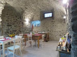 une salle à manger avec une table en bois et des chaises blanches dans l'établissement B&B Casa Taralin, à Teglio