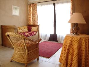 un salon avec une chaise et une table avec une lampe dans l'établissement La Guéritaulde, à La Tour-dʼAigues
