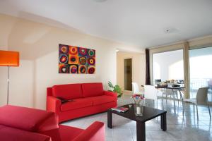 a living room with a red couch and a table at Casa Vacanze Samira in Fondachello