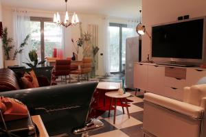 sala de estar con TV, sofá y mesa en Incantevole appartamento anni 50', en Soiano del Lago