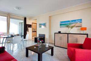 a living room with a red couch and a table at Casa Vacanze Samira in Fondachello