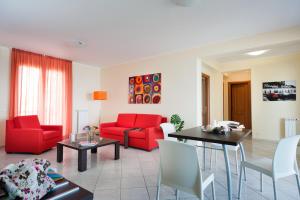 a living room with red furniture and a table at Casa Vacanze Samira in Fondachello
