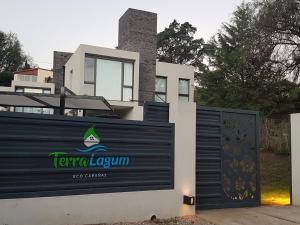 a house with a sign in front of a fence at Terralagum in Villa Parque Siquiman +62 photos