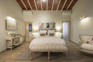 a bedroom with a large bed and a couch at Borgo Argiano in Castelnuovo Berardenga