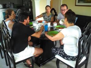 een groep mensen die rond een tafel zitten bij Posada Halley View in Providencia