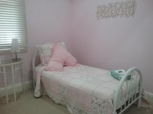 a small bed with a pink pillow on it at Langley Cottage B&B in Coonabarabran
