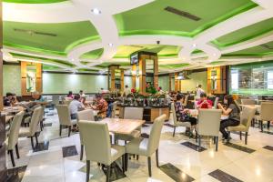 a group of people sitting at tables in a restaurant at Orchardz Jayakarta in Jakarta