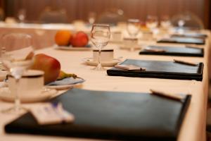 a table with glasses and plates of food on it at Wyndham Garden Donaueschingen in Donaueschingen