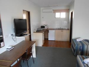 a living room filled with furniture and a tv at Kanimbla Motor Inn in Tocumwal