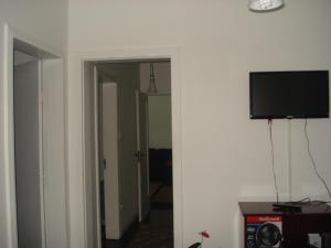 pasillo con TV de pantalla plana en la pared en 123m Apartamento Centro de Curitiba, en Curitiba