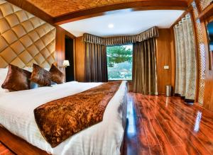 a bedroom with a large bed and a large window at Royal Grandiose Pahalgam in Pahalgām +88 photos