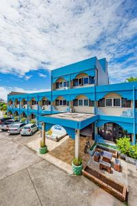 a blue building with cars parked in a parking lot at Pure Phuket Residence in Phuket