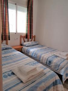 three beds in a room with a window at Apartment La Mata LM004 in La Mata