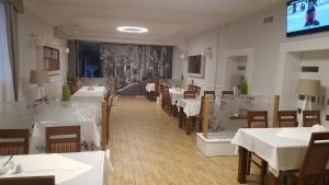 a dining room with tables and chairs and a tv at Zielony Dworek in Kraśnik