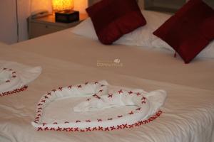 a bed with red and white towels on it at Rasdhoo Coralville in Rasdhoo