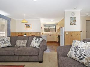 a living room with a couch and a kitchen at Cedar Cottage - Tudor Village in Bright