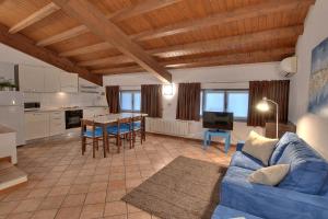 a living room with a blue couch and a kitchen at Residence il Cascinetto in Pavia