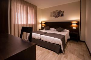 a hotel room with a large bed and a window at Complejo O Piñeiral A Fonsagrada in Fonsagrada