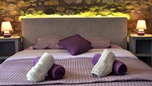 ein Bett mit drei Kissen darauf mit zwei Lampen in der Unterkunft Le Mas de la Colombe in Grospierres