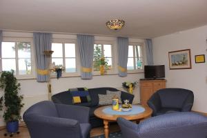 ein Wohnzimmer mit einem Sofa, Stühlen und einem Tisch in der Unterkunft Appartementpark Seeblick in Plau am See